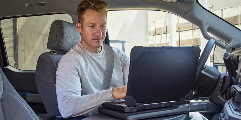 2025 Ford Super Duty F-350 DRW Man Working on laptop inside vehicle